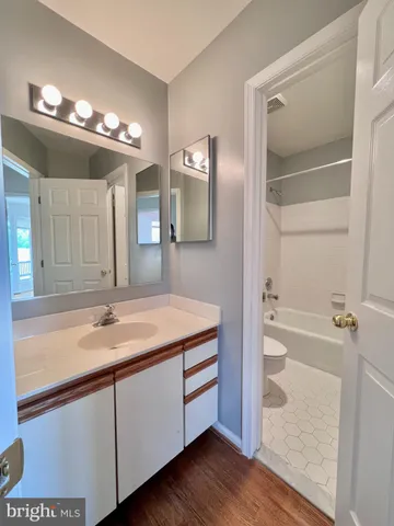 a bathroom with a granite countertop sink a large mirror and a bathtub