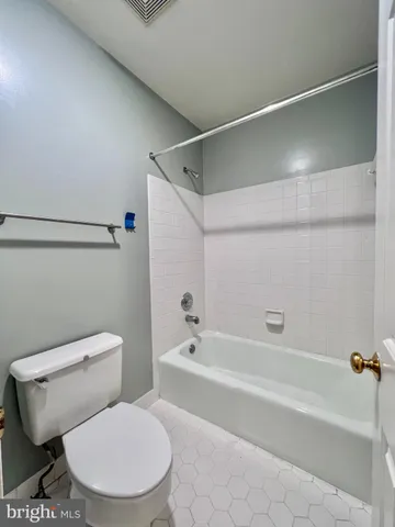 a white toilet sitting next to a bath tub