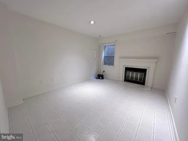 an empty room with a fireplace and a window
