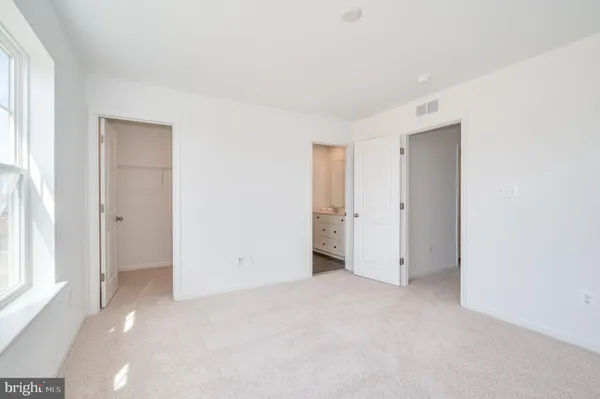 an empty room with windows and closet