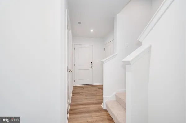 a view of a hallway with wooden floor and staircase