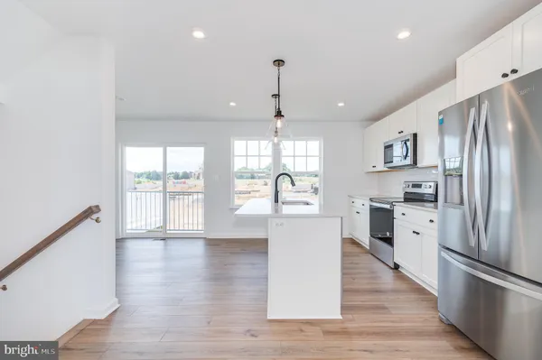 a open kitchen with white cabinets and stainless steel appliances