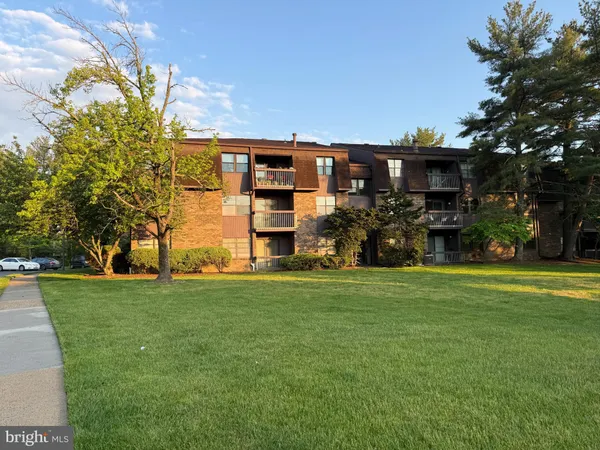 a view of a house with a big yard and large trees