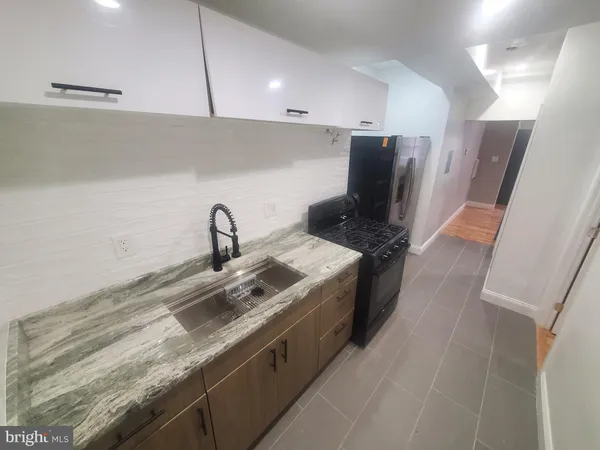 a kitchen with stainless steel appliances granite countertop a sink and a stove