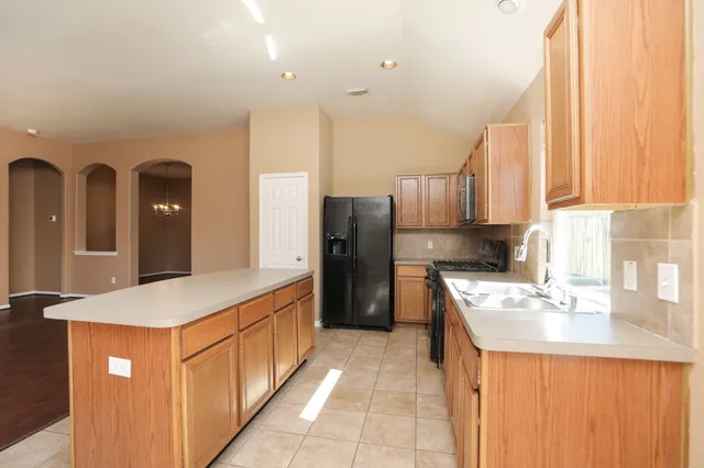 a kitchen with stainless steel appliances granite countertop a refrigerator and a stove
