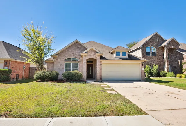 a front view of a house with yard and garage