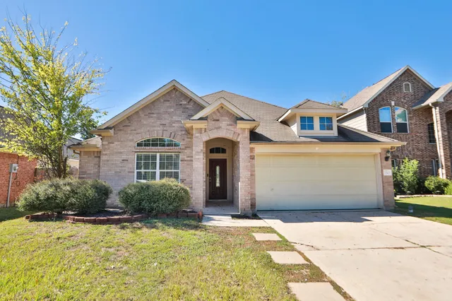 a front view of a house with a yard and garage