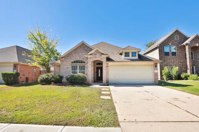 a front view of a house with yard and garage