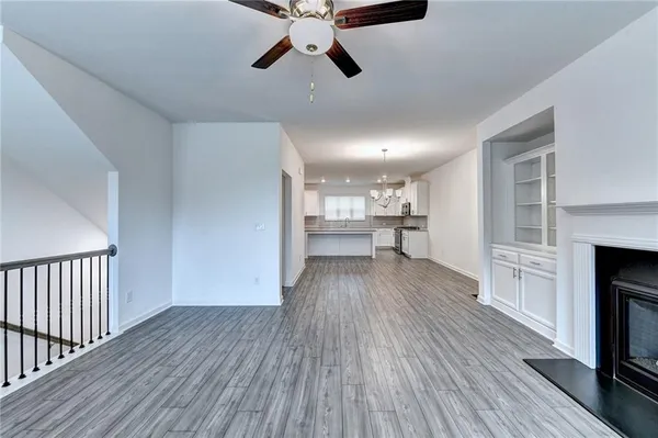a view of a kitchen with wooden floor a sink a refrigerator and window