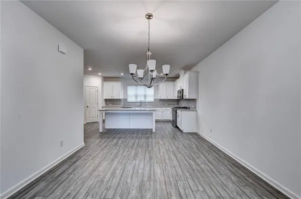 a view of a kitchen with wooden floor and stainless steel appliances