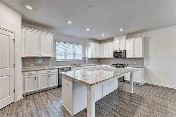 a kitchen with a sink stove and white cabinets