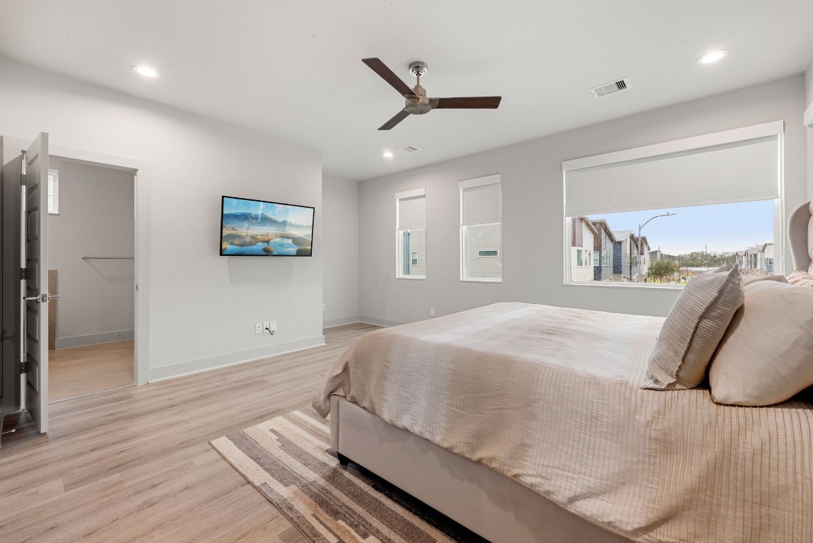 5722 Rucio Lane, Unit A Houston, TX 77092 - Photo 13 of 29 a spacious bedroom with a bed and a painting on the wall