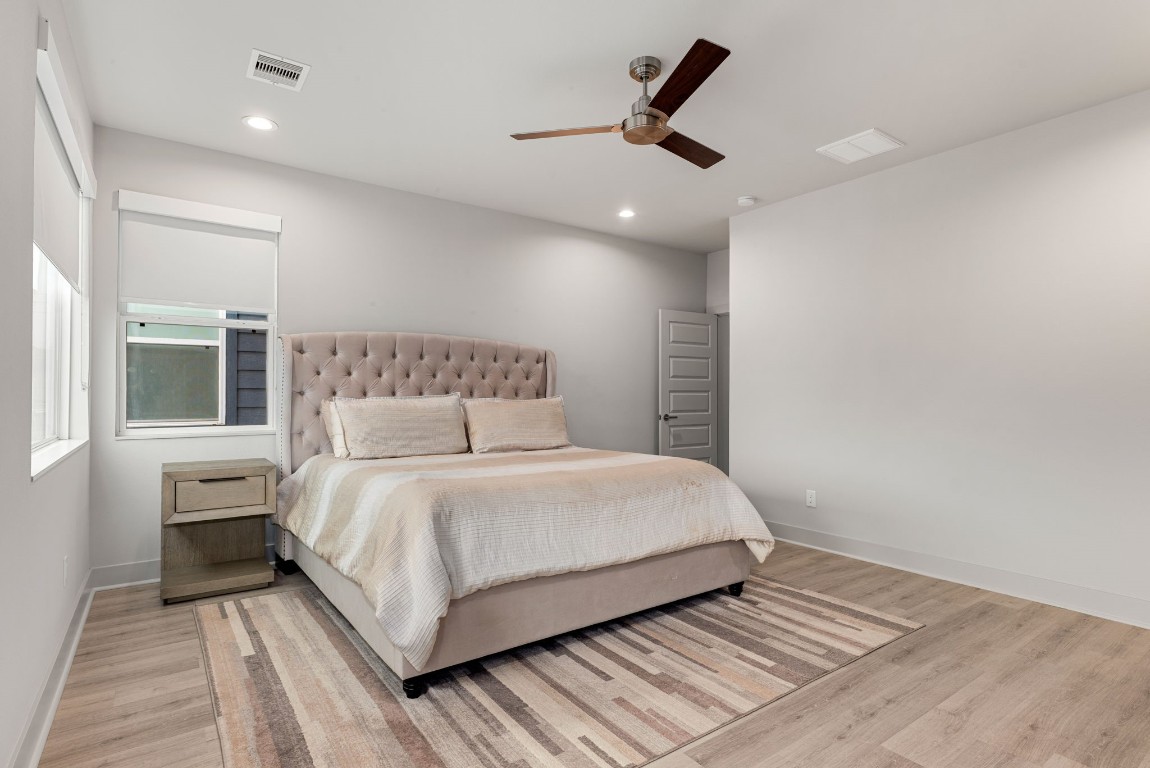5722 Rucio Lane, Unit A Houston, TX 77092 - Photo 14 of 29 a bedroom with a large bed and a ceiling fan