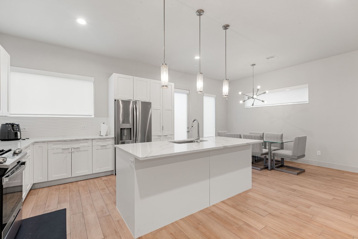 5722 Rucio Lane, Unit A Houston, TX 77092 - Photo 8 of 29 a large kitchen with kitchen island a stove a sink a center island and wooden floor