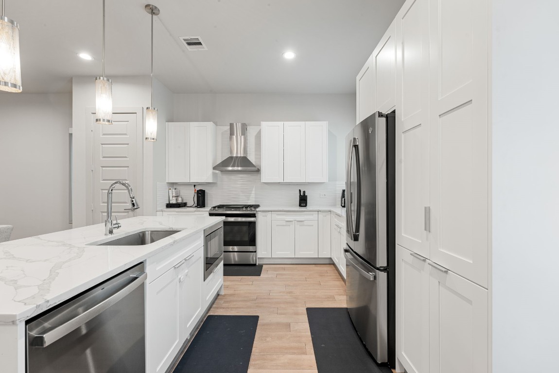 5722 Rucio Lane, Unit A Houston, TX 77092 - Photo 10 of 29 a kitchen with white cabinets and stainless steel appliances