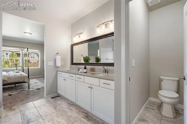 a spacious bathroom with a toilet sink and a mirror
