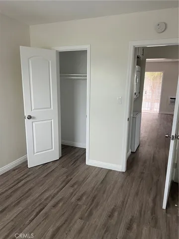 an empty room with wooden floor and closet