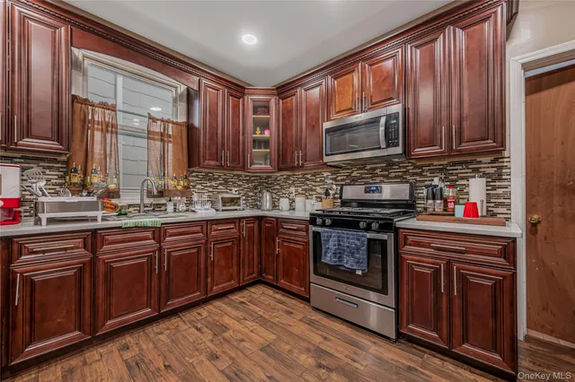 a kitchen with stainless steel appliances granite countertop wooden cabinets stove top oven and sink