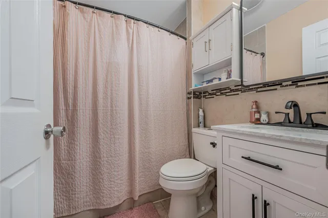a bathroom with a sink a toilet and shower curtain