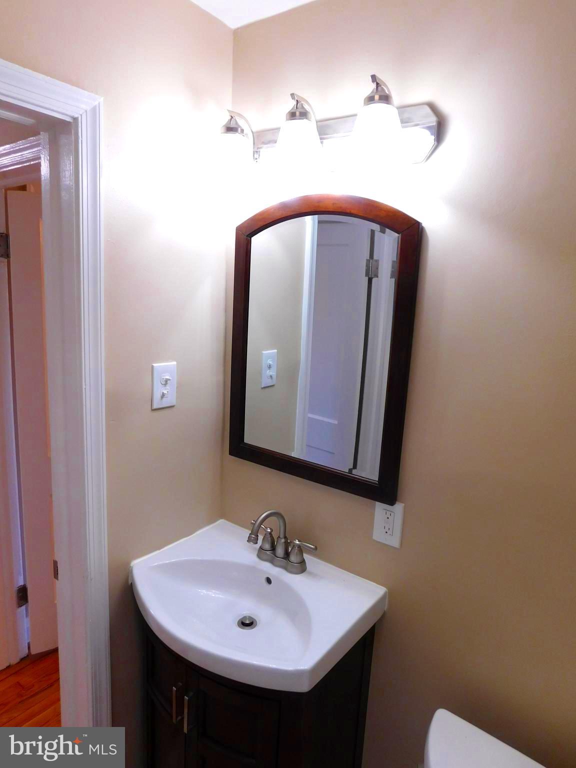 4012 Rexmere Road Baltimore, MD 21218 - Photo 21 of 29 a bathroom with a sink and a mirror