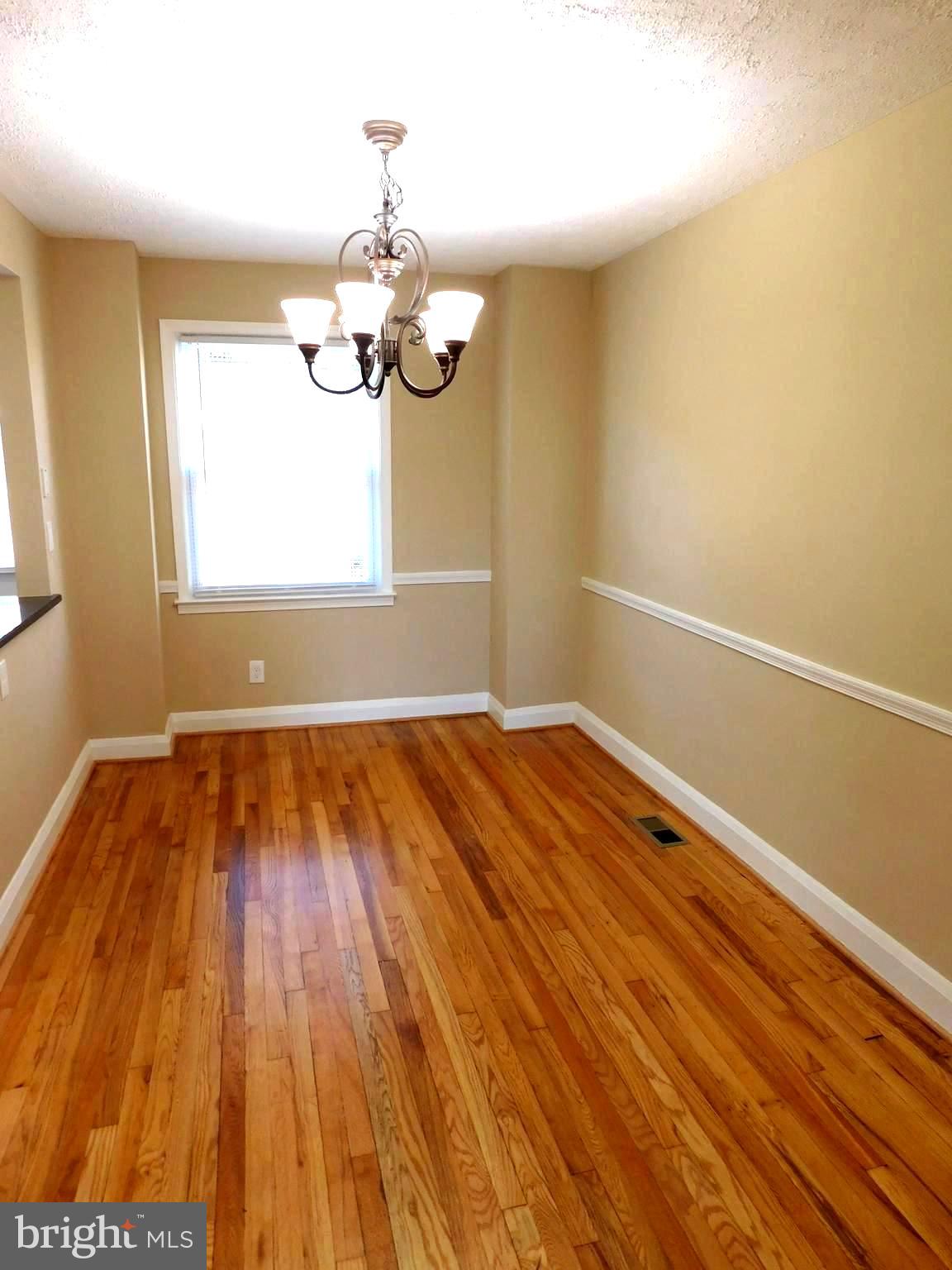 4012 Rexmere Road Baltimore, MD 21218 - Photo 5 of 29 a view of room with wooden floor and chandelier