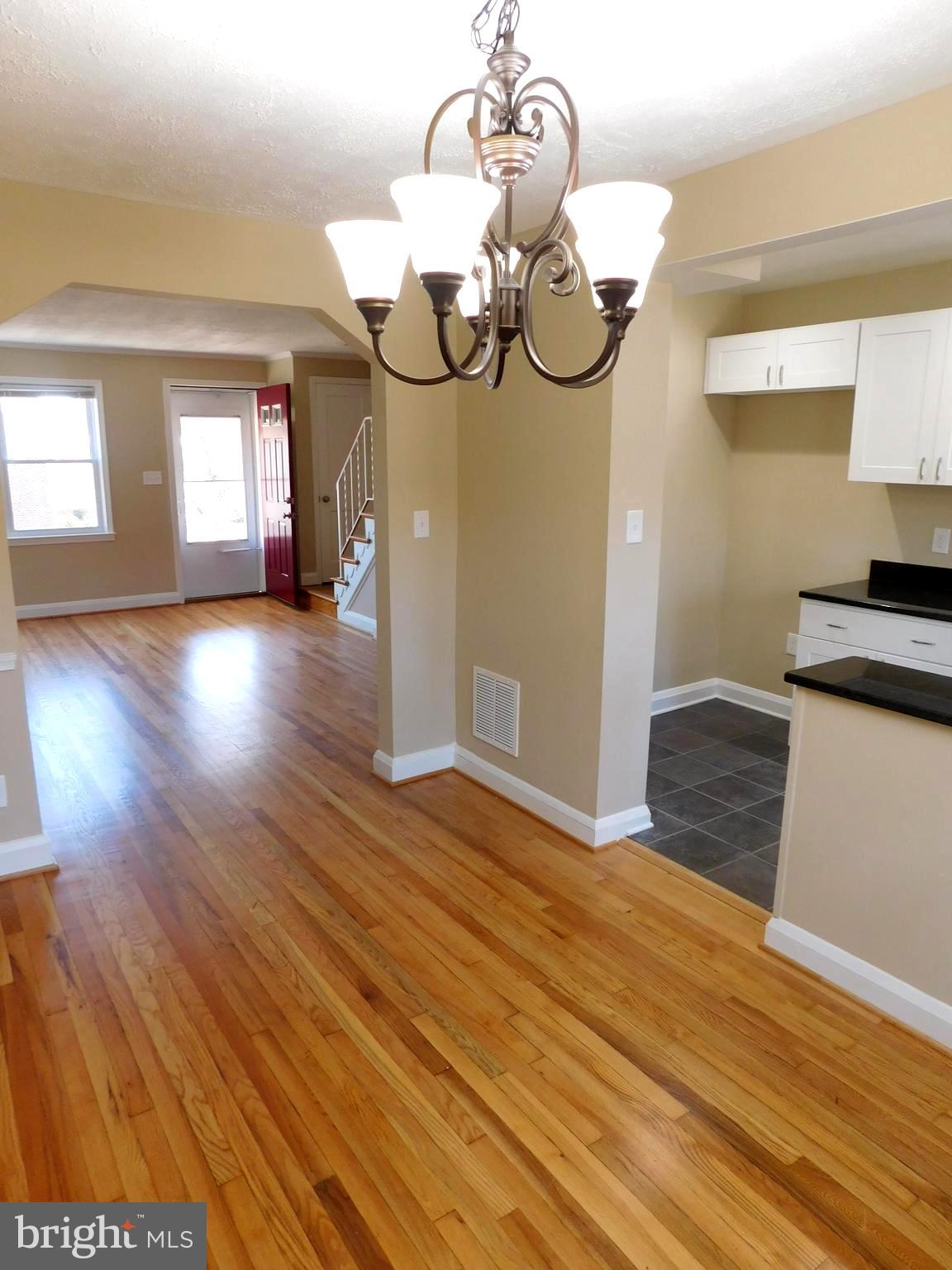 4012 Rexmere Road Baltimore, MD 21218 - Photo 7 of 29 a view of a kitchen with wooden floor and a chandelier