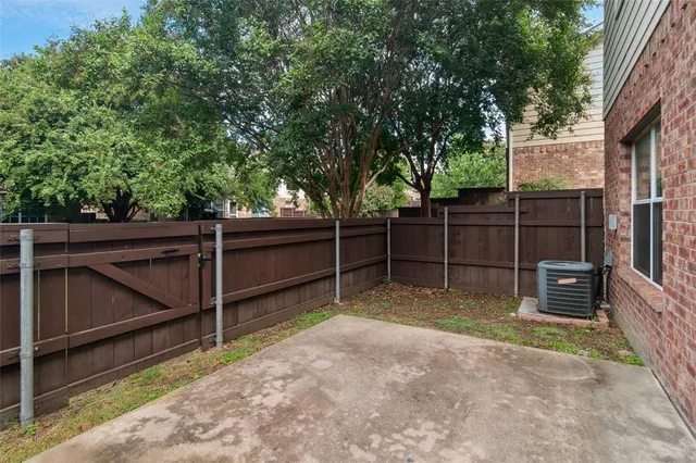 a view of a backyard with wooden fence and a large tree