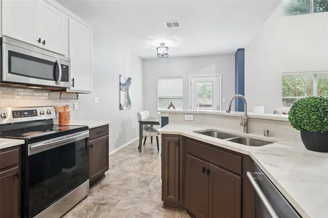 a kitchen with a sink stove and microwave