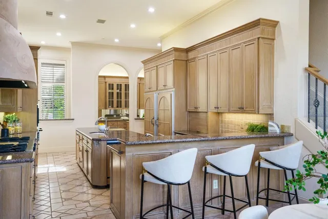 a kitchen with stainless steel appliances granite countertop table chairs and a large window