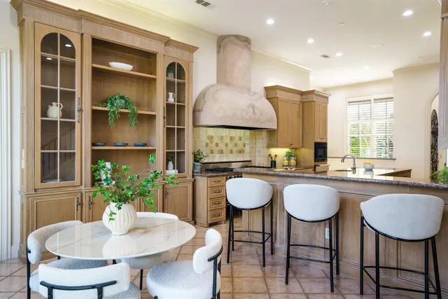 a kitchen with granite countertop a table and chairs in it