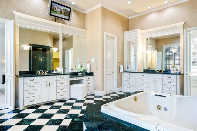 a large white bathroom with a bathtub sink and mirror
