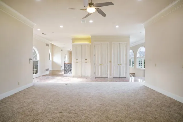 a view of an empty room and a ceiling fan window