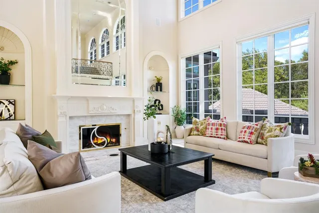a living room with furniture fireplace and a large window