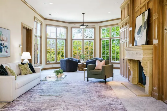 a living room with furniture large windows and a fireplace