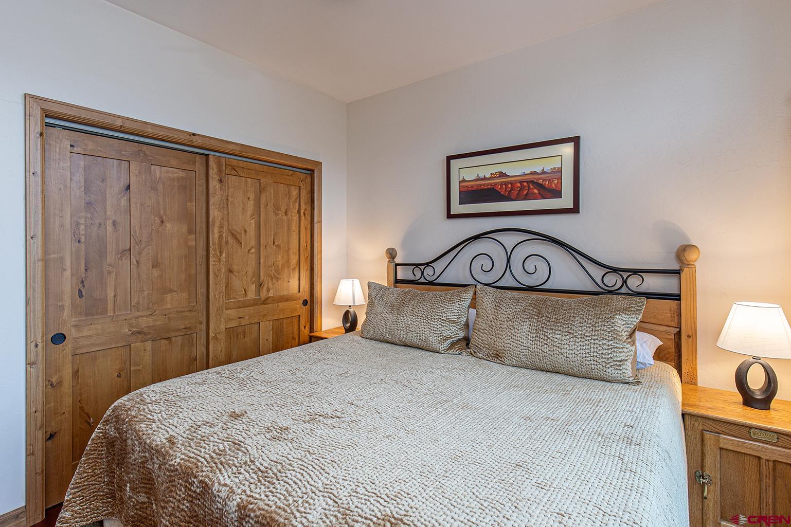 1099 Main Avenue, Unit 410 Durango, CO 81301 - Photo 11 of 34 a bedroom with a bed and a painting on the wall