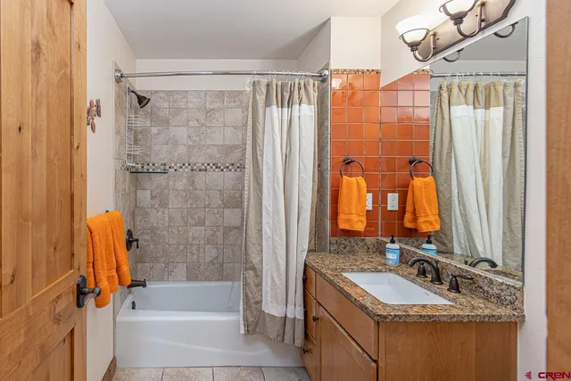 a bathroom with a tub sink and mirror