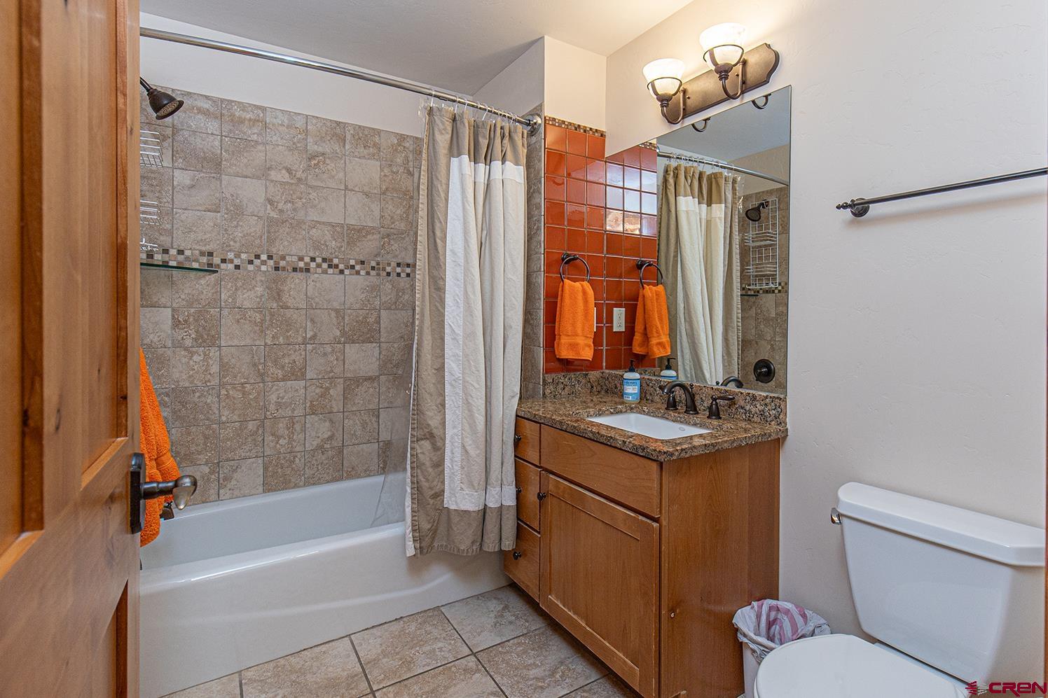 1099 Main Avenue, Unit 410 Durango, CO 81301 - Photo 15 of 34 a bathroom with a granite countertop sink toilet and shower