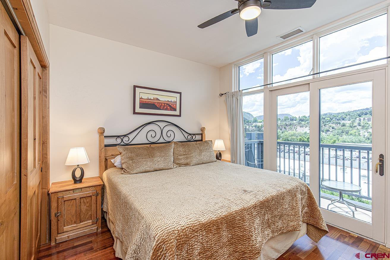 1099 Main Avenue, Unit 410 Durango, CO 81301 - Photo 10 of 34 a bedroom with a large bed and a chandelier