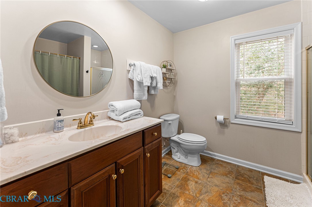 4775 Stormont Road Hartfield, VA 23071 - Photo 33 of 45 Full bath featuring a shower with curtain, vanity, and stone finish floors