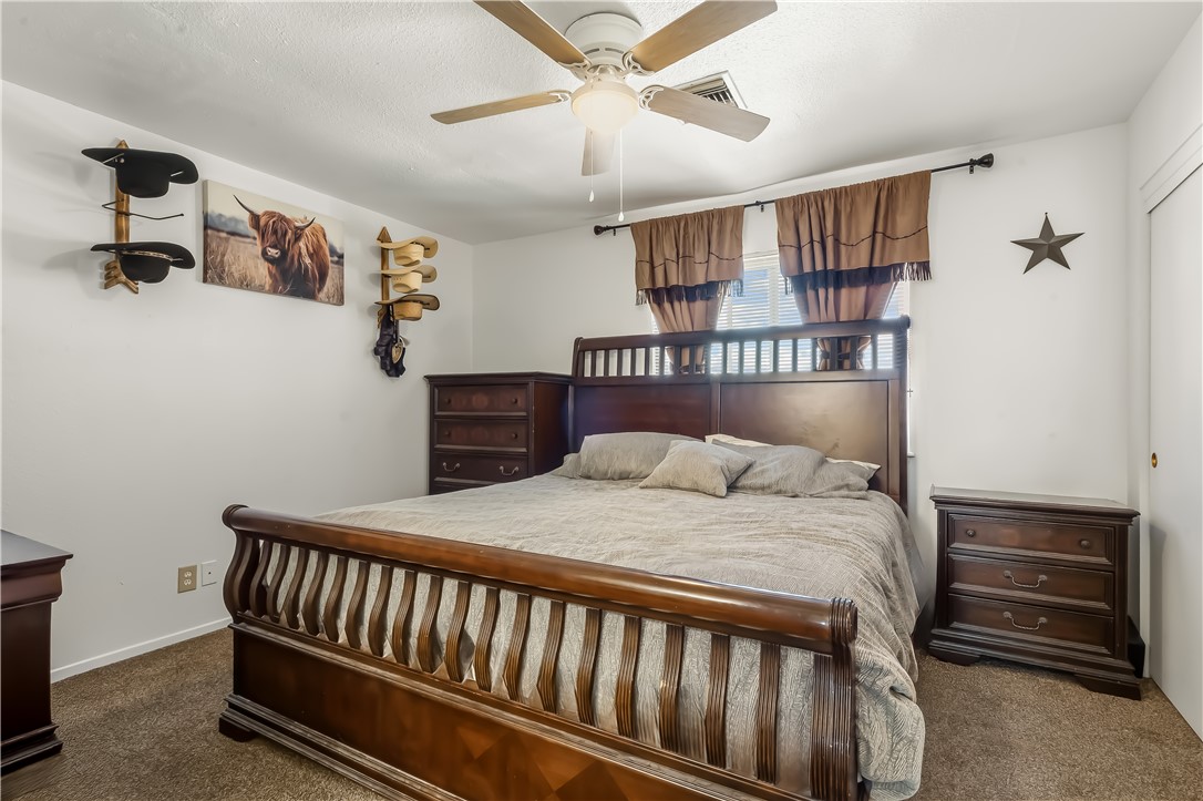 1666 Palma Road Bullhead City, AZ 86442 - Photo 13 of 22 Bedroom with dark carpet and ceiling fan