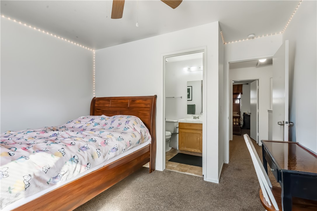 1666 Palma Road Bullhead City, AZ 86442 - Photo 16 of 22 Bedroom featuring dark carpet, ensuite bath, and ceiling fan