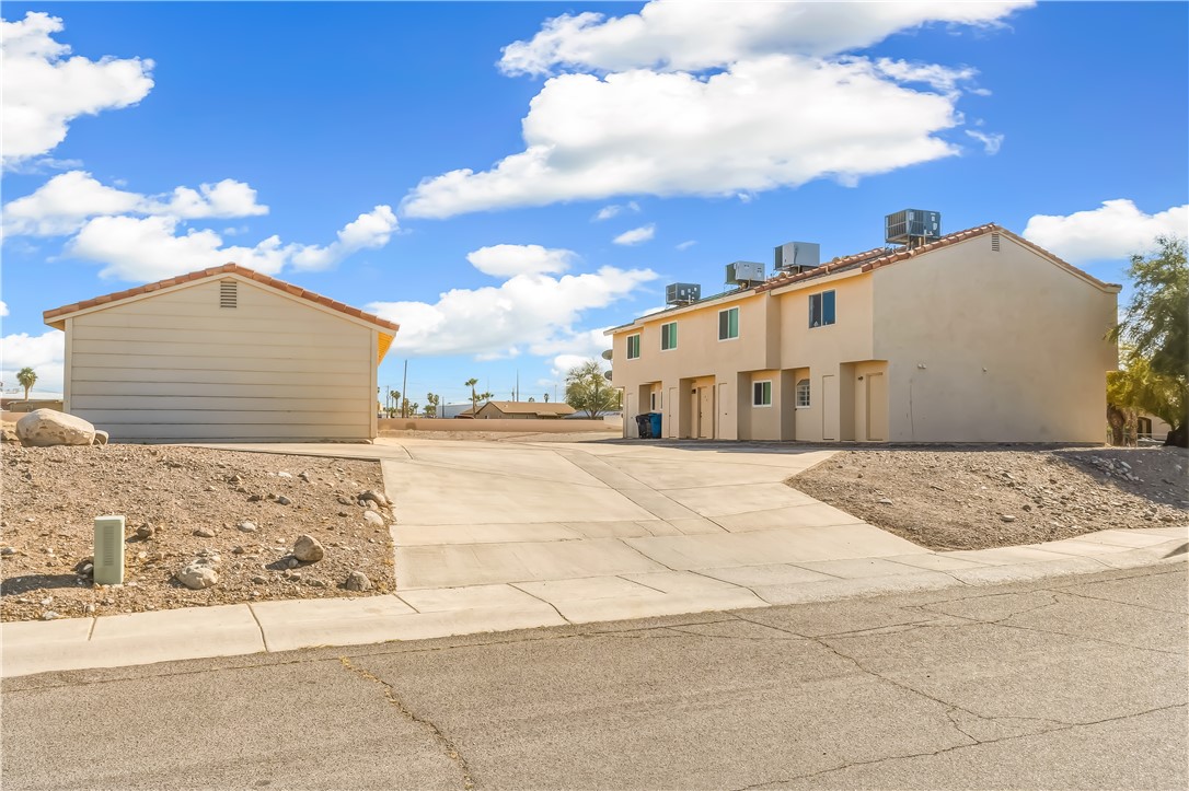 1666 Palma Road Bullhead City, AZ 86442 - Photo 5 of 22 View of side of property featuring driveway and stucco siding