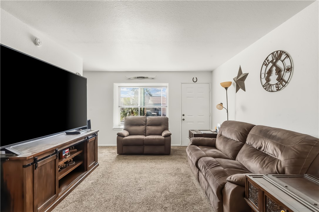 1666 Palma Road Bullhead City, AZ 86442 - Photo 6 of 22 Living room featuring light colored carpet and a textured ceiling