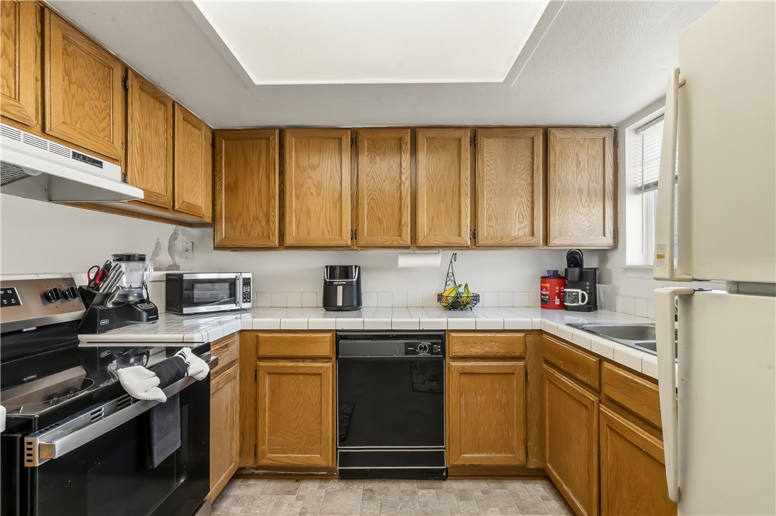 1666 Palma Road Bullhead City, AZ 86442 - Photo 9 of 22 Kitchen with wood finish cabinets, stainless steel appliances, and tile counters
