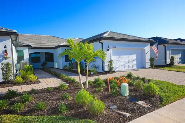 an aerial view of a house with a garden and lake view