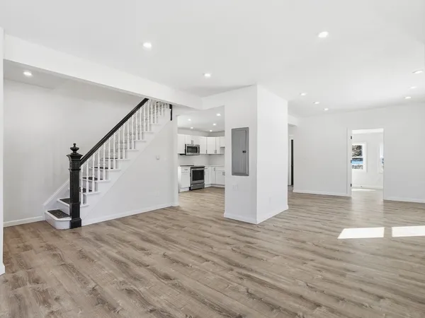 a view of a livingroom with kitchen and stairs