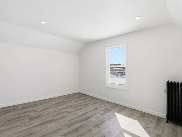 an empty room with wooden floor and window