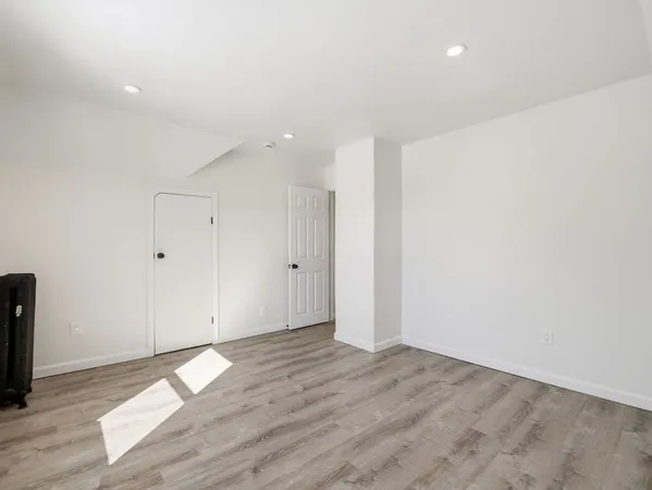 a view of an empty room with wooden floor