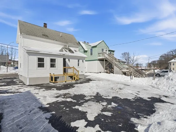 a view of a house with snow on the road