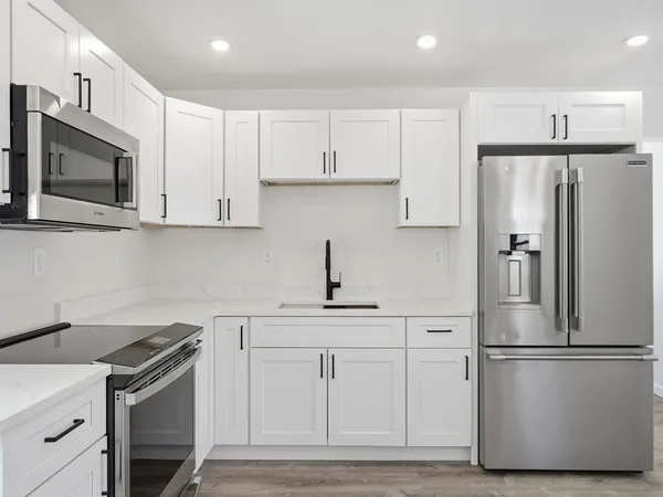 a kitchen with white cabinets and stainless steel appliances